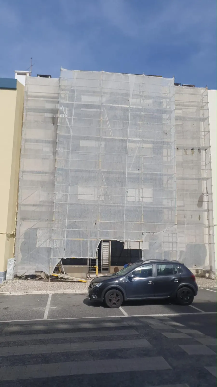 Edifício em pintura de fachada com rede de proteção