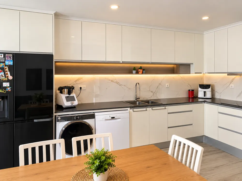 Cozinha remodelada com mesa de madeira e iluminação quente